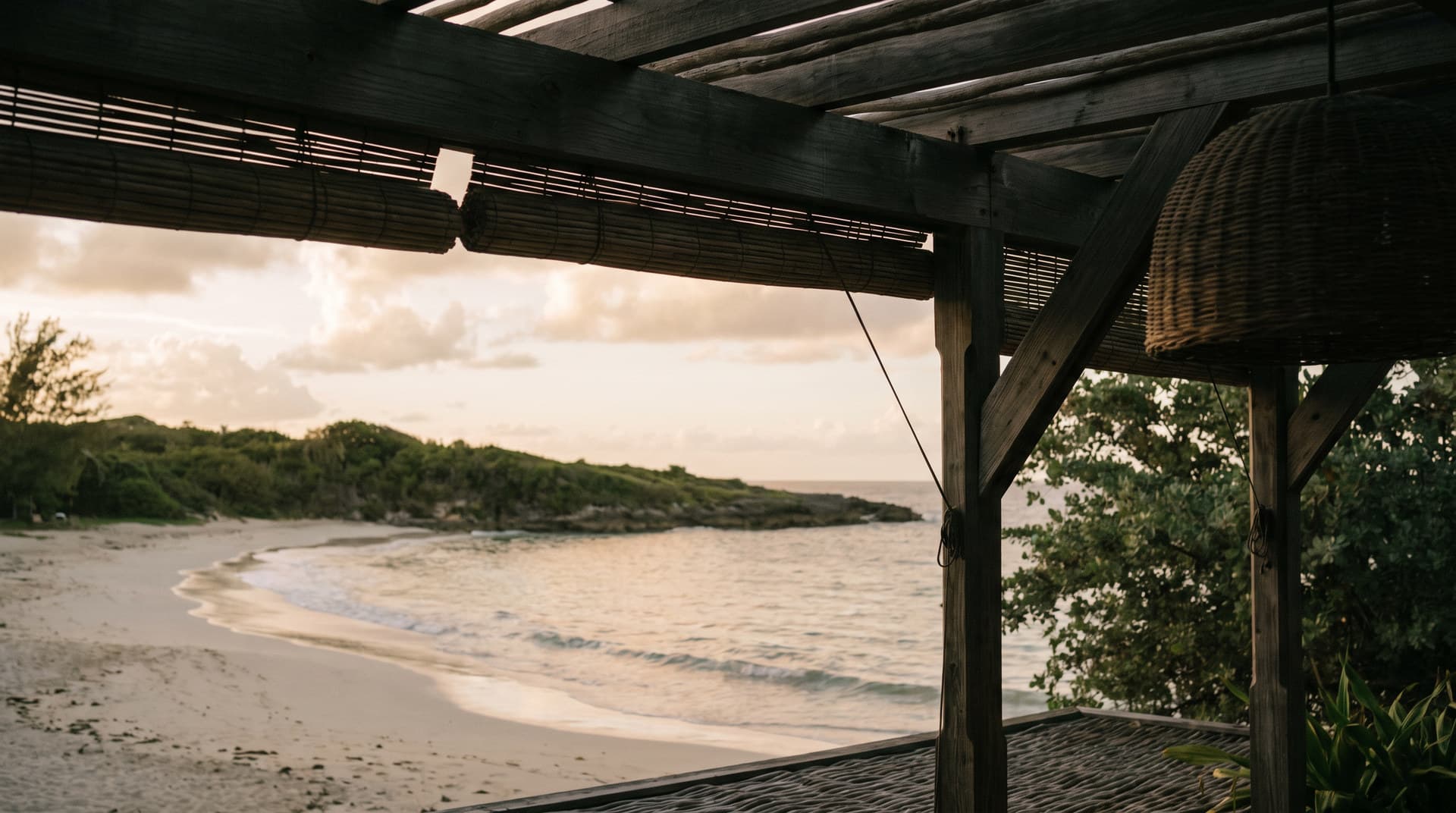 A quiet coastline at the end of the day, seen from a shaded terrace.