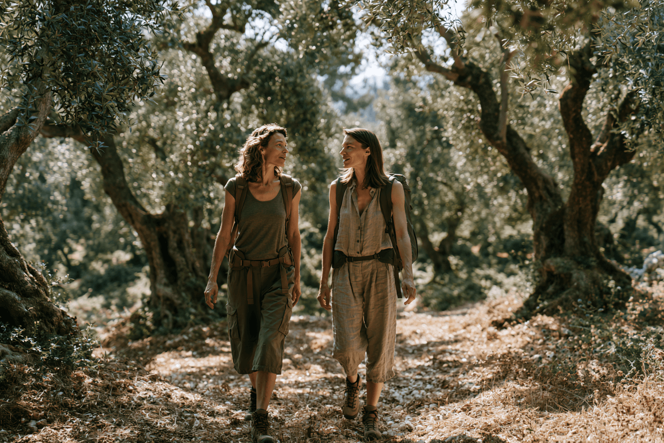 Two women walk slowly along a quiet street in conversation.